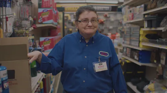 Video still of a woman working in a shop.